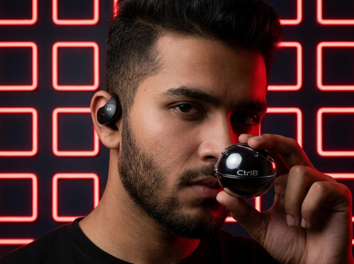 User wearing CTRL8 T2 over-the-ear earbuds with ergonomic fit, ideal for immersive listening in a vibrant setting.